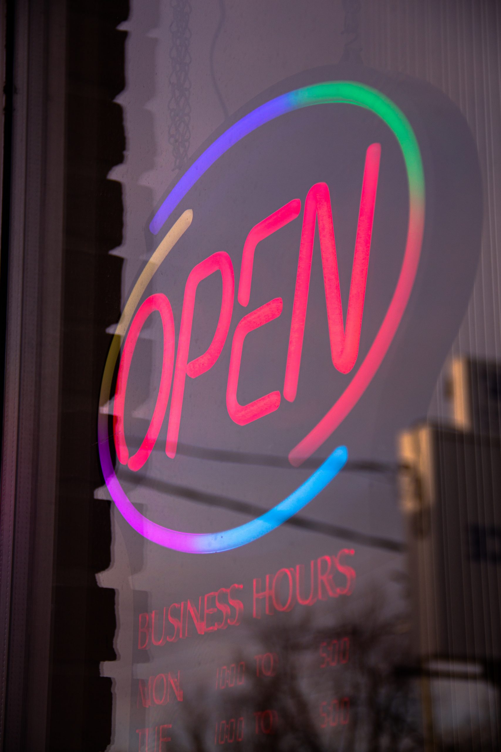 'Open' als leuchtender Schriftzug in einem Schaufenster